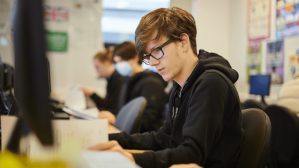 Male student sat at a computer