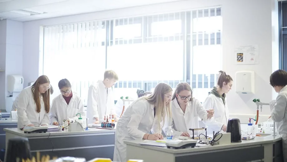 Chemistry students conducting experiments in the classroom. apply for colleges near me