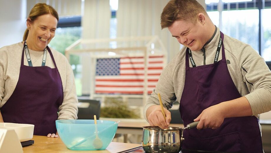 male student in a cooking lesson with a female teacher