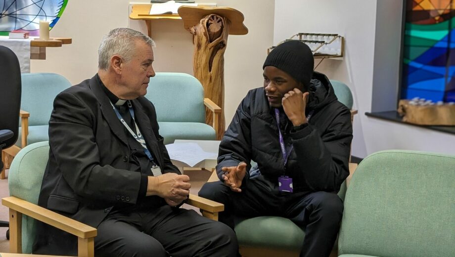photo of interfaithing week. A priest sat int he chaplaincy with a student