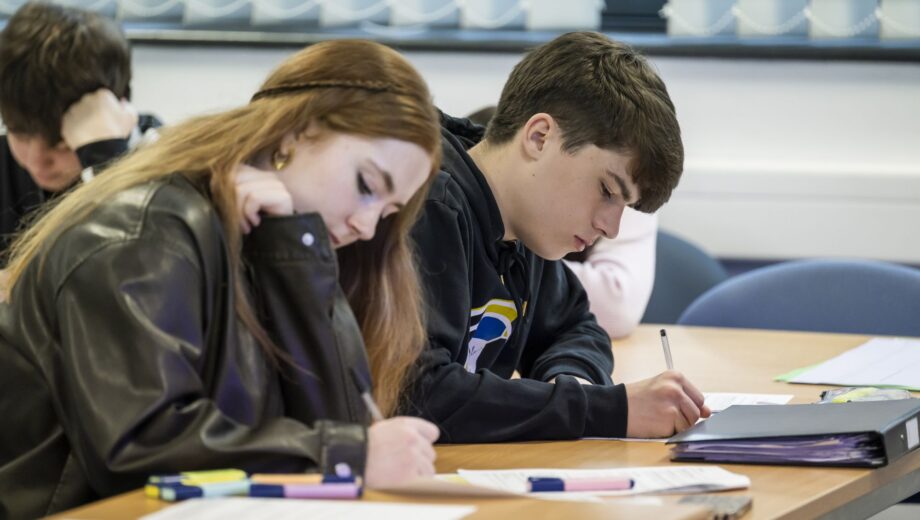 Male and female student, head down studying